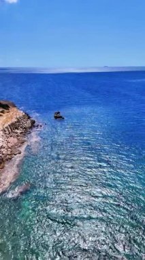 Yunanistan 'ın Dedeağaç kenti yakınlarındaki Petrota Sahili ve Mesimvria Sahili yakınlarındaki temiz mavi su, kayalık kıyı şeridi ve Trakya Denizi' ndeki yaz ışığı ile ilgili hava aracı videosu.