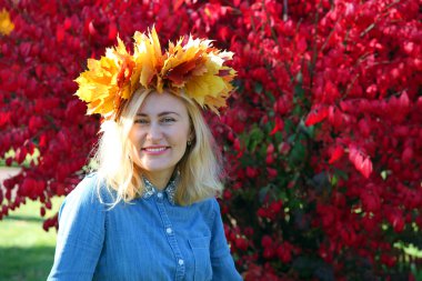 yaprakları bir çelenk içinde oturan kız