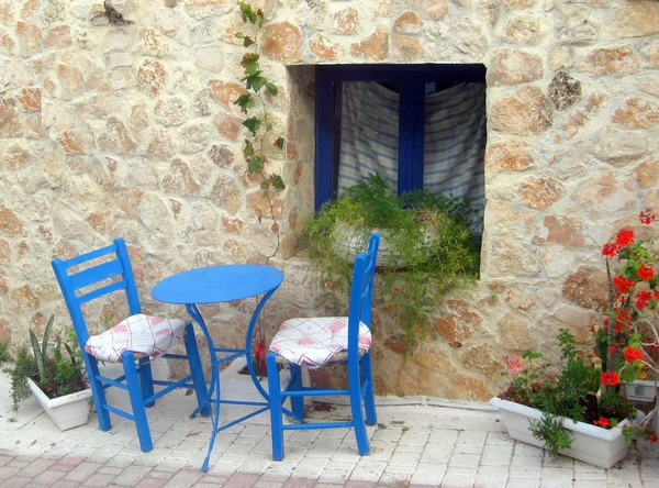 Dwa krzesła i stół w małym dziedzińcu na grecki — Zdjęcie stockowe