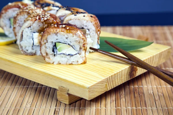 Conjunto de sushi japonés sabroso en una bandeja de madera — Foto de Stock