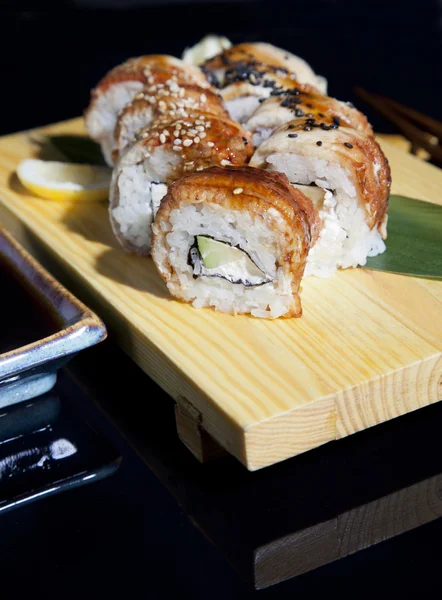 Conjunto de sushi japonés sabroso en una bandeja de madera — Foto de Stock