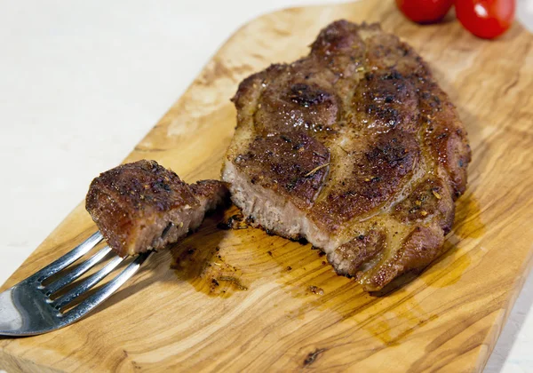 Filete a la parrilla jugoso en una tabla de madera —  Fotos de Stock