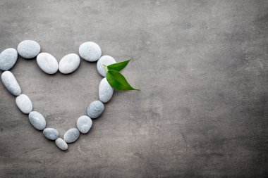 Kalp kaplıca taşlarından, gri arka planda..