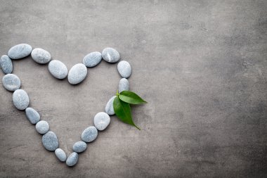 Kalp kaplıca taşlarından, gri arka planda..