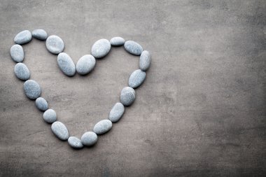 Kalp kaplıca taşlarından, gri arka planda..