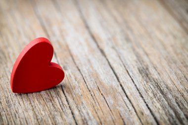 Tahta bir arka planda kırmızı kalp şeklinde..