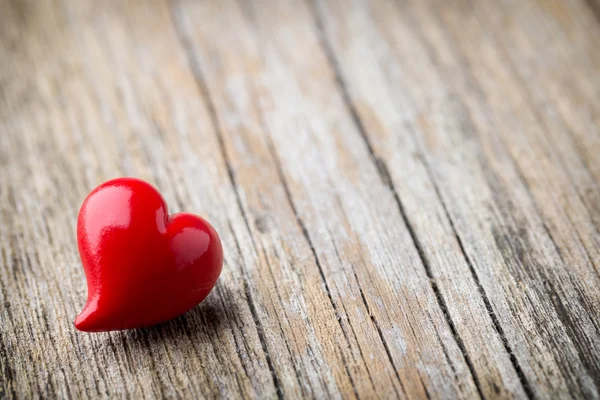 Rojo en forma de corazón sobre un fondo de madera. — Foto de Stock