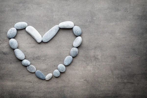 Kalp kaplıca taşlarından, gri arka planda..