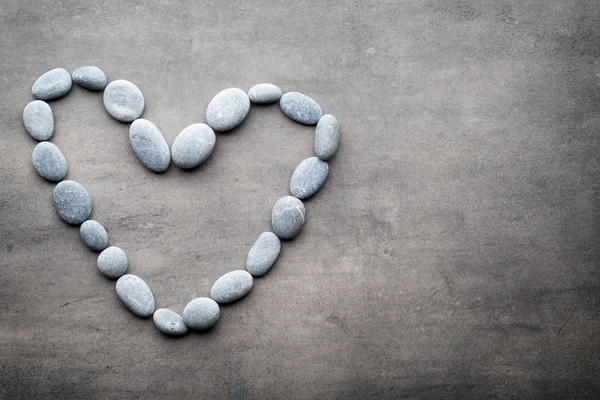 Kalp kaplıca taşlarından, gri arka planda..