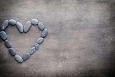 Kalp kaplıca taşlarından, gri arka planda..