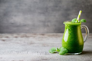 Ispanaklı smoothie, gri arka planda..