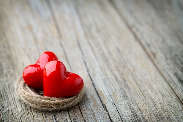 Dos rojo en forma de corazón sobre un fondo de madera . — Foto de Stock