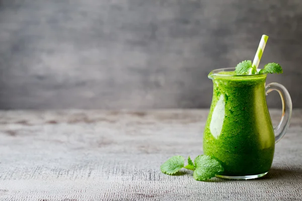 Ispanaklı smoothie, gri arka planda..