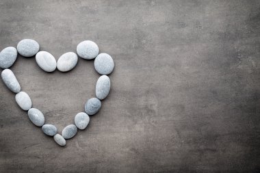 Kalp kaplıca taşlarından, gri arka planda..