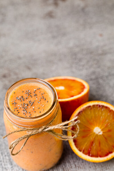 Red orange smoothie, on the grey  background.