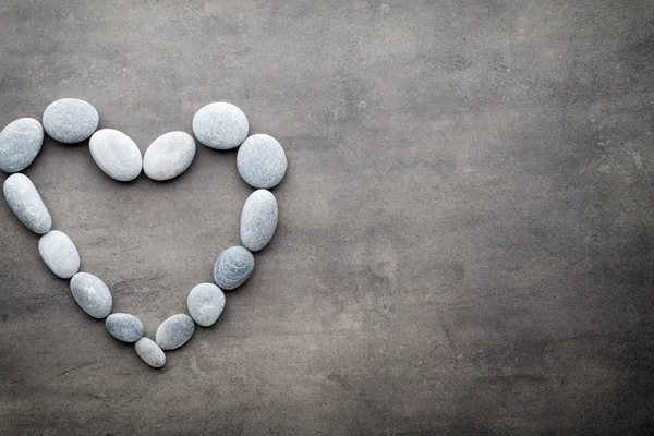 Kalp kaplıca taşlarından, gri arka planda..
