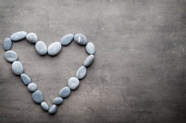Kalp kaplıca taşlarından, gri arka planda..