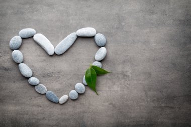 Kalp kaplıca taşlarından, gri arka planda..