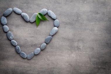 Kalp kaplıca taşlarından, gri arka planda..
