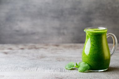 Ispanaklı smoothie, gri arka planda..