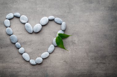 Kalp kaplıca taşlarından, gri arka planda..