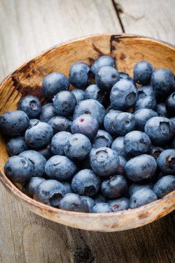 Tahta bir masada kasede yaban mersini..