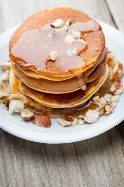 Ahşap arka planda ballı ev yapımı krep yığını.