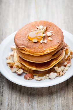 Ahşap arka planda ballı ev yapımı krep yığını.