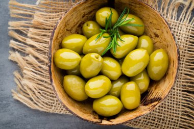 Taze zeytin ve gri arka plan. Kase ve kaşıkta zeytin.