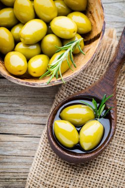 Taze zeytin ve gri arka plan. Kase ve kaşıkta zeytin.