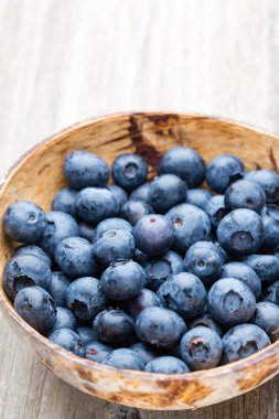 Tahta bir masada kasede yaban mersini..