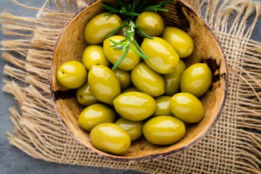 Taze zeytin ve gri arka plan. Kase ve kaşıkta zeytin.