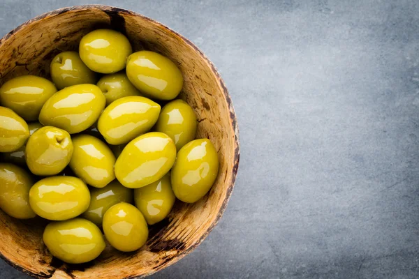 Fresh olives and gray background. Olives in bowl and spoon. — Stock Photo, Image