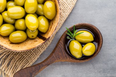 Taze zeytin ve gri arka plan. Kase ve kaşıkta zeytin.