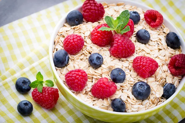 Oatmeal porridge with berries. Raspberries and blueberries.