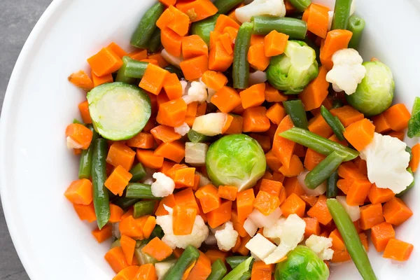 Las verduras frescas se mezclan en un tazón blanco. —  Fotos de Stock