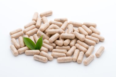 Beyaz arkaplanda Ginkgo biloba kapsülü.