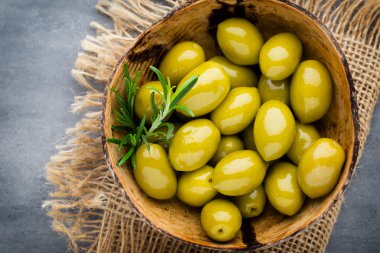 Taze zeytin ve gri arka plan. Kase ve kaşıkta zeytin.