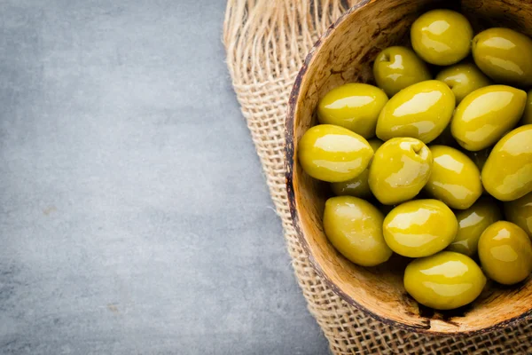 Fresh olives and gray background. Olives in bowl and spoon. — Stock Photo, Image