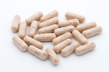 Beyaz arkaplanda Ginkgo biloba kapsülü.