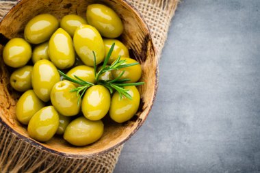 Taze zeytin ve gri arka plan. Kase ve kaşıkta zeytin.
