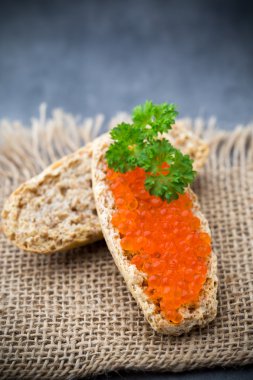 Ekmek taze krem peynir ve masada kırmızı havyar ile.