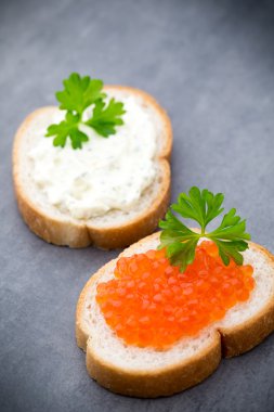 Ekmek taze krem peynir ve masada kırmızı havyar ile.