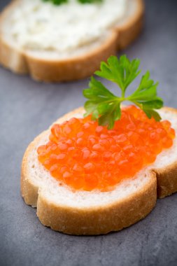 Ekmek taze krem peynir ve masada kırmızı havyar ile.