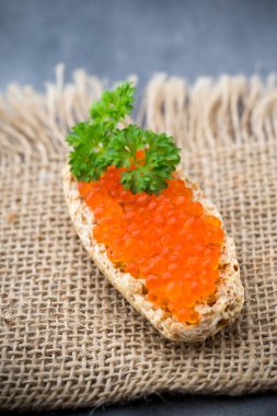 Ekmek taze krem peynir ve masada kırmızı havyar ile.