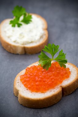 Ekmek taze krem peynir ve masada kırmızı havyar ile.