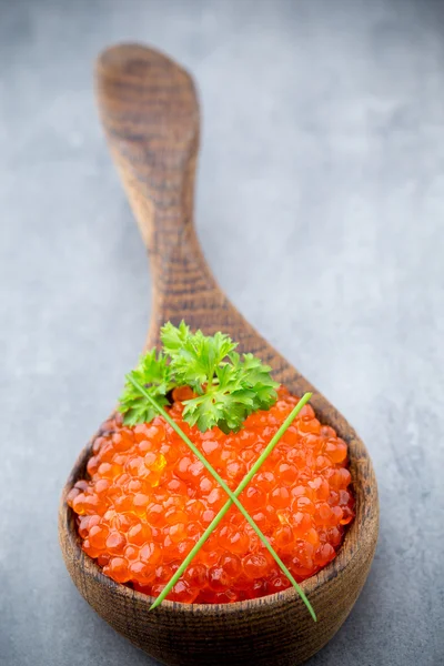 Lachskaviar mit Löffel auf grauem Hintergrund. — Stockfoto