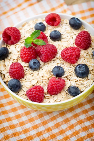 Oatmeal porridge with berries. Raspberries and blueberries.