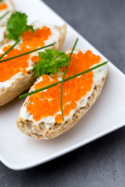 ekmek arası beyaz plaka üzerinde kırmızı havyar.