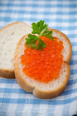 Ekmek taze krem peynir ve masada kırmızı havyar ile.